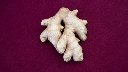 Fototapeta na wymiar closeup of piece of ginger on red table