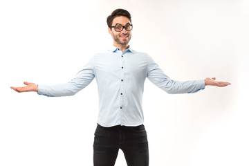 Young happy man showing presentation, pointing on placard over gray background