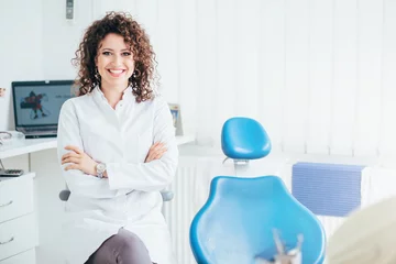 Poster Portrait of female dentist. She standing at her office and she has beautiful smile. © likoper