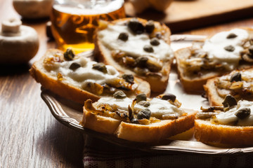 Crostini with fried mushrooms, onion and mozzarella cheese