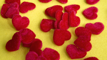 closeup of small red soft hearts on yellow table