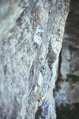 green climbing quickdraw fixed on jumper on the cliff. climbing equipment