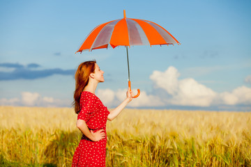 photo of beautiful young woman with umbrella on the wonderful field background