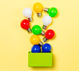 photo of colorful bulbs and green box on the wonderful studio yellow background