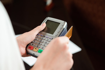 Hand swiping debit card on pos terminal