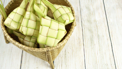Ketupat in the bamboo basket on the wooden table