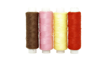 thread red, yellow, pink and brown on a white background