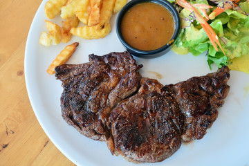 Ribeye steak with vegetable salad and french fries