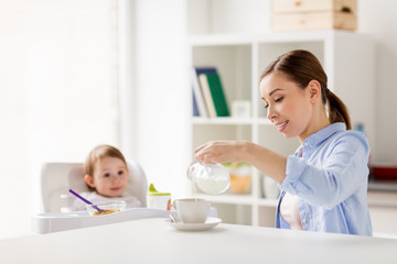 happy mother and baby having breakfast at home