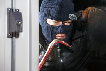 Intruder with crow bar and hand gun