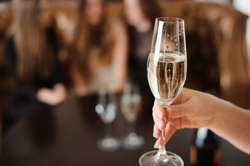 glass of champagne on the background of friends at a party