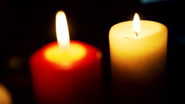 Three candles on table in empty dark room