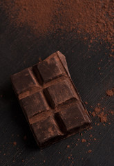Dark chocolate bar covered with chocolate powder