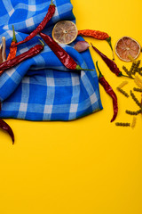 Dried red chilly peppers and fusilli on blue plaid tablecloth