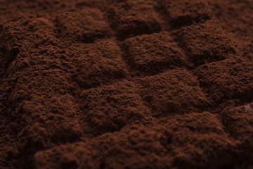 Close-up of a dark chocolate bar covered in chocolate powder