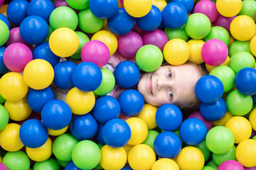 Child lies in colorful balls