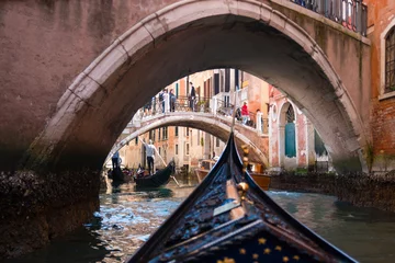 Wall murals Gondolas View from gondola under old bridge in street of Venice