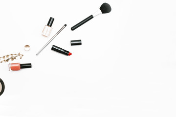 Makeup brushes, nail polish and lipstick on white background. Copy space, flat lay, top view. Beauty blog theme