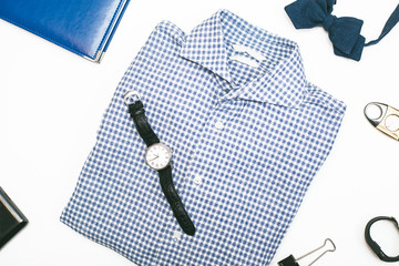 Men`s plaid shirt, a tie, watch, bow tie and accessories on white background. Male fashion concept. Flat lay, top view