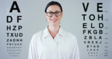 Portrait of a female doctor with white coat and stethoscope smiling looking into camera on white...