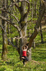 Young woman doing yoga in a forest