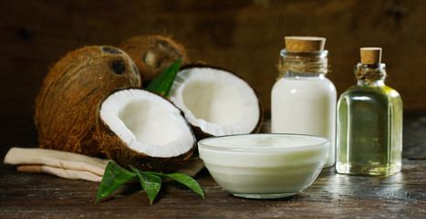 Fresh nourishing coconut milk moisturizing cream for hands, face and skin, on a dark wooden background, concept: spa, skincare, beauty, healthy lifestyle, bio products, ecologic products, massage.