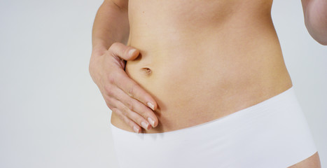 Beautiful body of a young girl showing off that she is in perfect ,on white background.Concept:diet,proper nutrition,sports body,slender body,work on yourself,love yourself,achieve,caring for the body