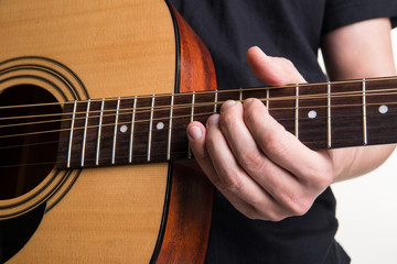Fototapeta na wymiar The guitarist plays the acoustic guitar close-up. Horizontal frame