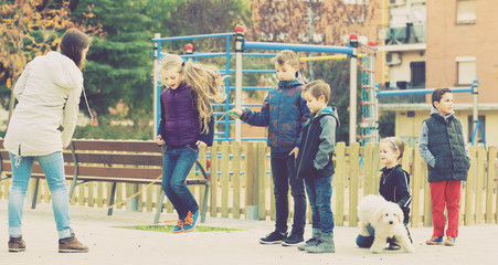 Children playing rubber band jumping game and laughing
