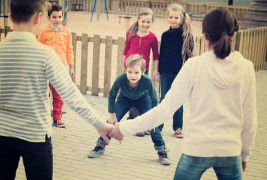 Group of ordinary children playing red rover