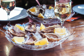 Oysters and wine. Oysters on ice with lemon. Seafood and white wine.