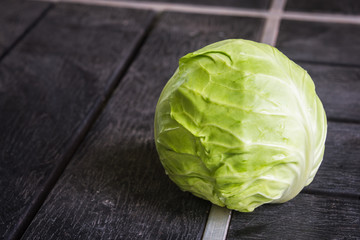 Green cabbage isolated on black wood background.