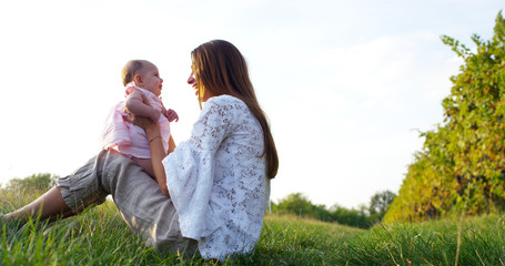 in a beautiful and happy sunny day , a mother and baby little girl play and are happy immersed in the colorful nature and happiness , the baby laughs happy . concept of happiness , love and nature.	