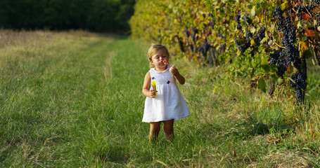 a little girl dressed in a vintage lawn run close to a tree in sunset happy little girl in nature. concept of nature and sustainability, connection with nature and the green world.