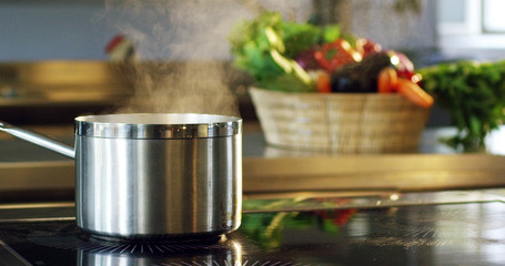 in an Italian professional kitchen a chef pours salt on a dish or in the water to boil the Italian pasta concept of healthy and light food.
