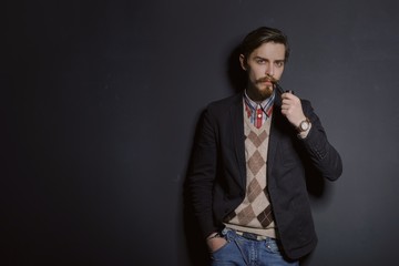 Studio portrait of a serious young businessman wearing a black suit on black background, copy space