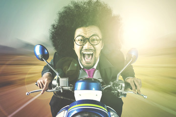 Afro businessman riding motorcycle