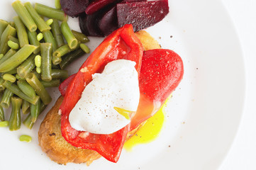 breakfast toast with roasted pepper and poached egg garnished with green beans and beetroot