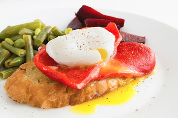 poached egg on toast with roasted and peeled bell pepper garnished with vegetables