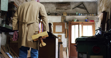 in an old carpentry shop a child and grandfather playing with a wooden airplane concept of tradition that continues over time	