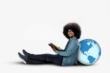 Afro student sitting with globe and book