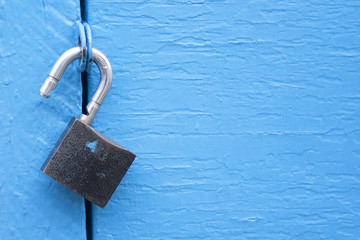Open lock on blue door background - template for text security business web concept. Unlock padlock - secure, protection, insurance and safety access, computer, IT, internet technology.