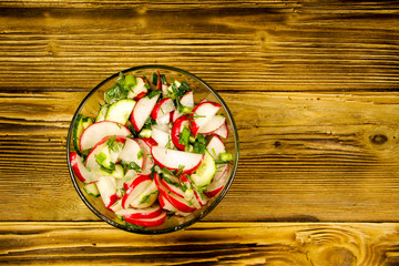 Radish salad in glass bowl on wooden table