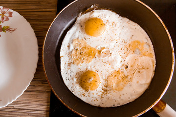 Cooking eggs in a frying pan at home on the stove