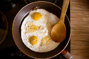 Cooking eggs in a frying pan at home on the stove