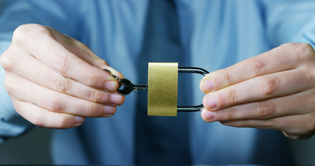 businessman show a padlock in safe sign with futuristic holographic about services and safety.concept of:password,Protection system files from technological hacker internet or banking system