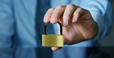 businessman show a padlock in safe sign with futuristic holographic about services and safety.concept of:password,Protection system files from technological hacker internet or banking system