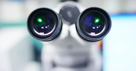 In a laboratory, a scientist with a pipette analyzes a colored liquid to extract the DNA and molecules in the test tubes. Concept: research, biochemistry, nature, pharmaceutical medicine