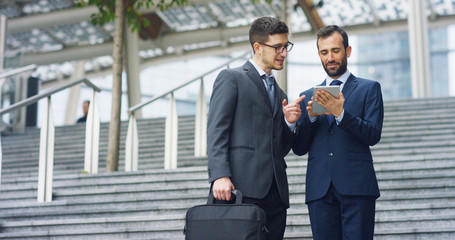 In the city two businessman they shake hands and smile before starting to collaborate on a project. Concept: teamwork, business, contract, bank.	