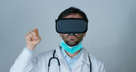A physician, surgeon, examines a technological digital holographic plate represented the patient's body, the heart lungs, muscles, bones. Concept: Futuristic medicine, world assistance, and the future